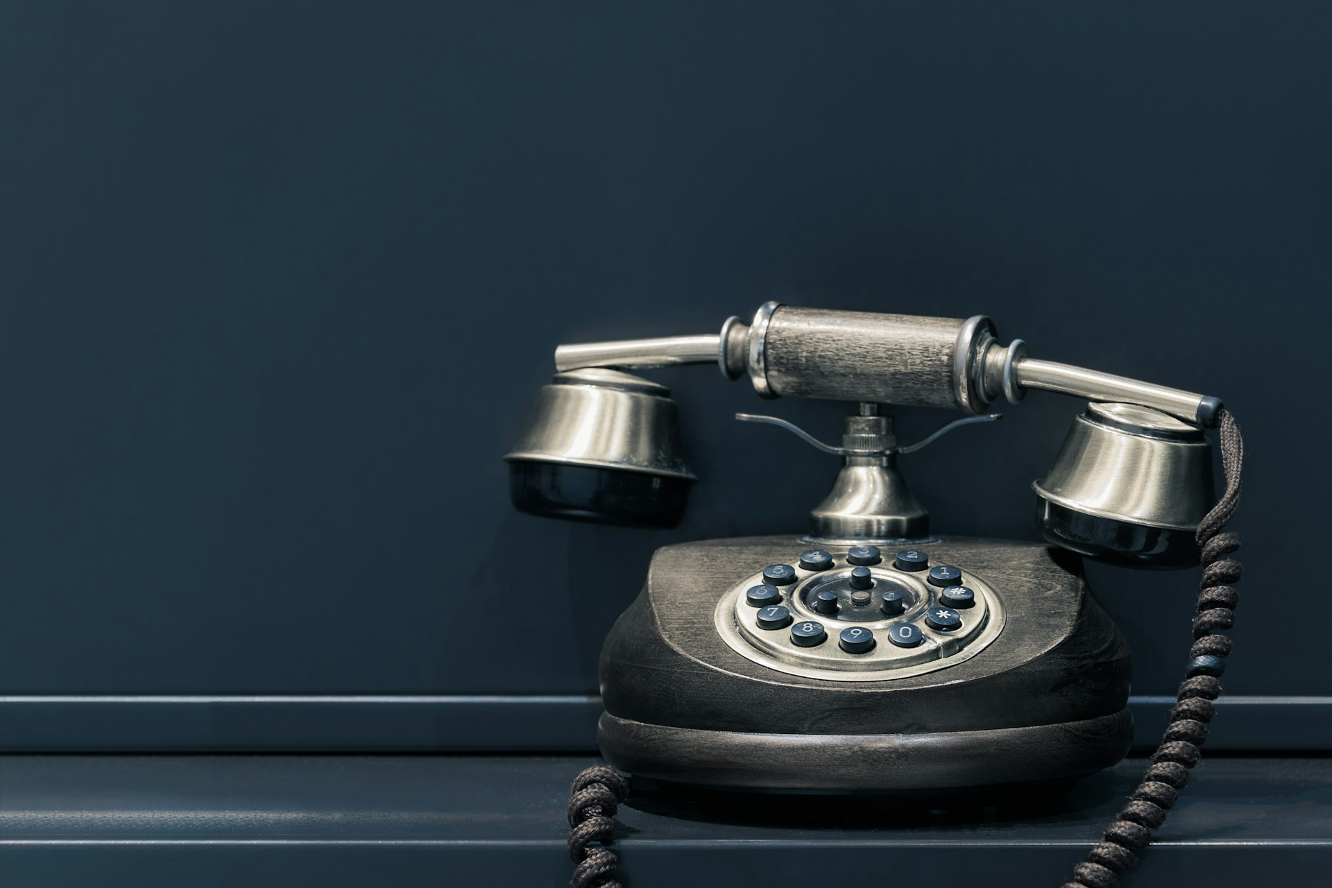 Photo of a vintage black rotary-style landline phone taken by Pawel Czerwinski